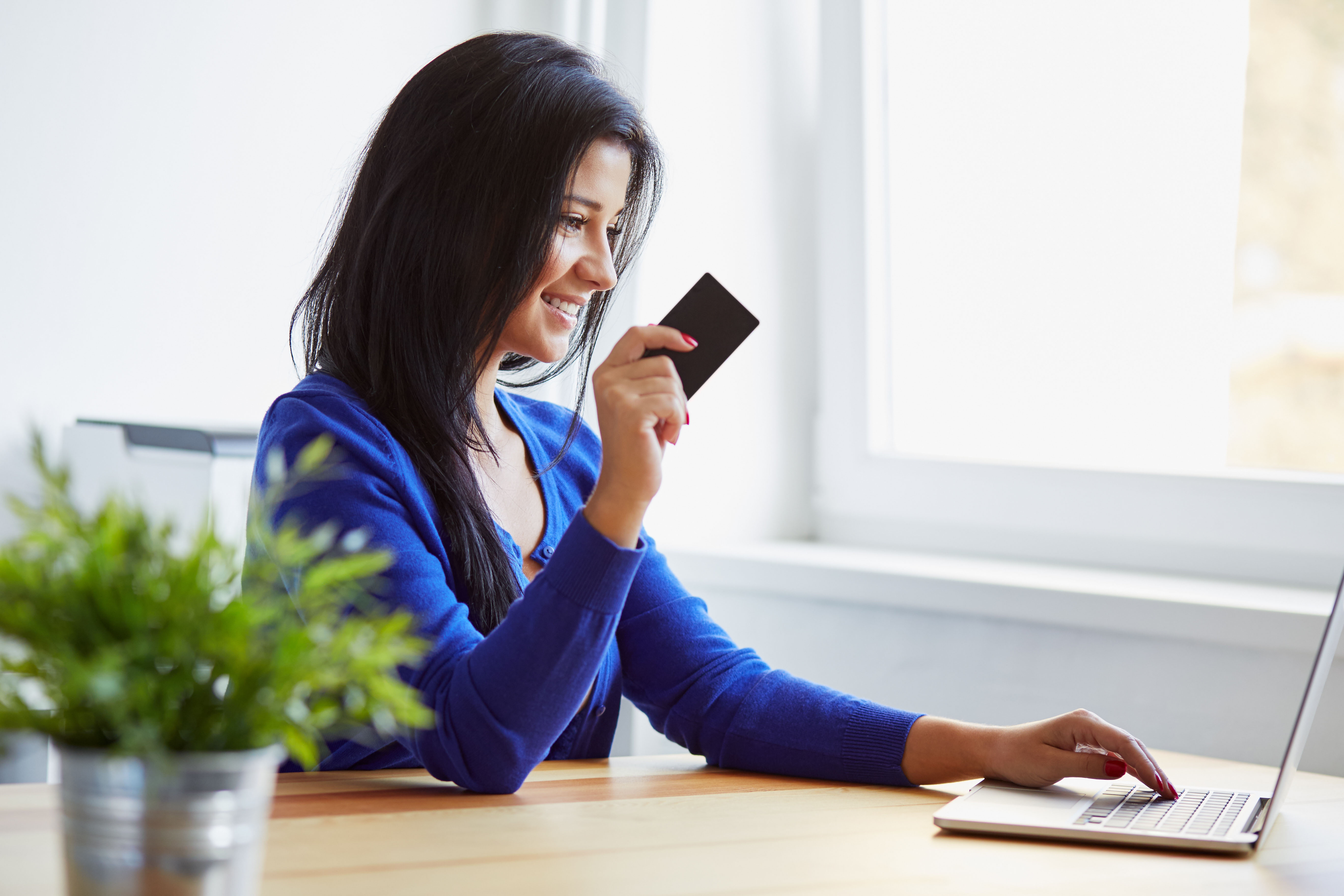 Woman paying with a credit card on the notebook